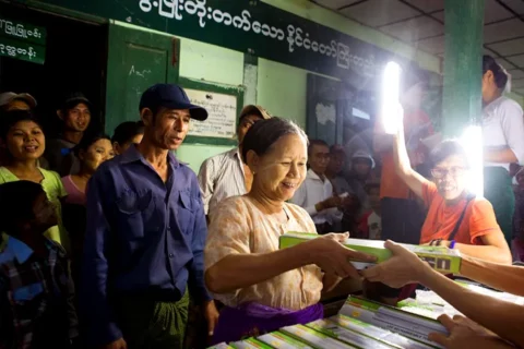 緬甸貧困村莊的居民正在領取菩提禪修機構發送的太陽能照明燈