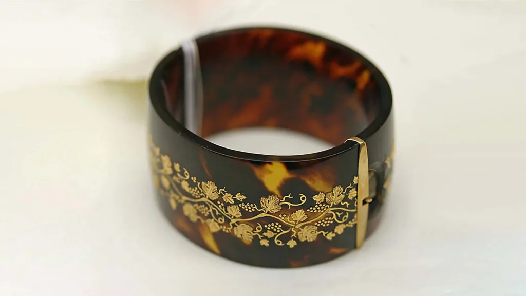 A bracelet made of tortoiseshell, adorned with beautiful botanical patterns. 