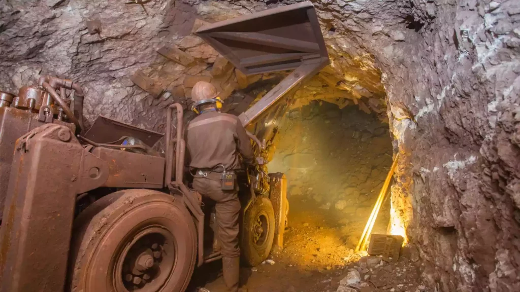 Workers explore holes in the mountain in search of gold