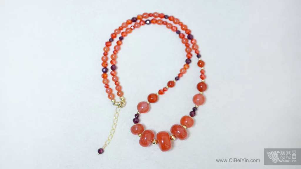 A necklace made of Nanhong Agate beads of varying sizes.