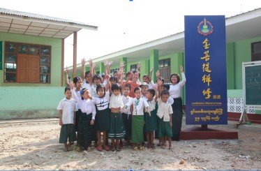 緬甸學童站在菩提禪修機構資助建設的校舍前合影