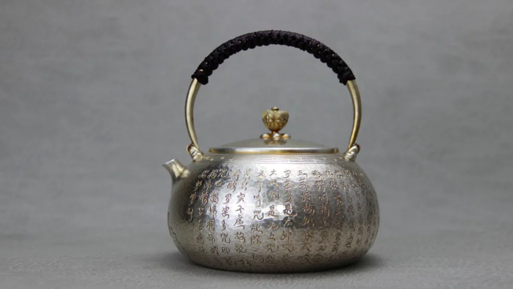 白銀製作的茶壺，上面刻滿文字