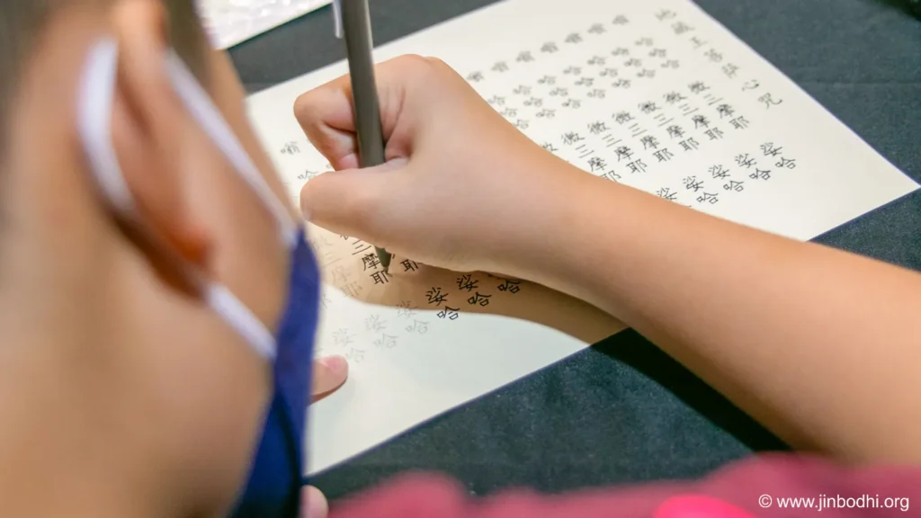 Children focused on copying the Heart Mantra of Ksitigarbha Bodhisattva.  